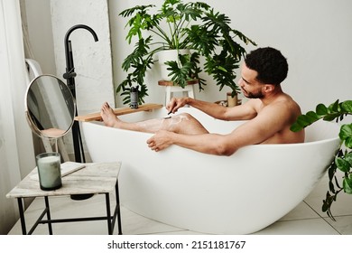 Man Shaving His Legs In Bathroom