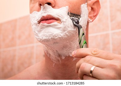 The man is shaving. Morning procedures. Morning of a young man.