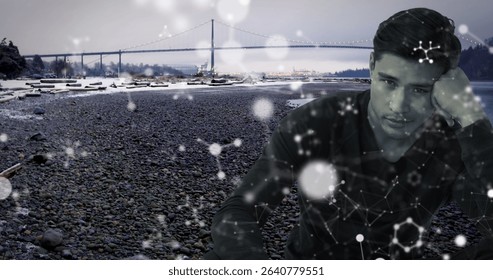 Man in shirt gazing on pebble beach by suspension bridge, driftwood and network overlay, copy space. Minimalist, contemplative, scenic, futuristic, natural, urban, technological - Powered by Shutterstock - Get 15% off with code: PIKWIZARD15