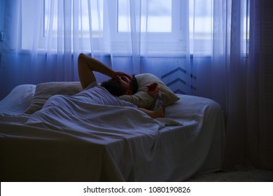 Man In Shirt Laying On Bed Awake, White Curtain On Background. Guy On Disappointed Painful Face Waking Up In Morning. Hangover Concept. Macho With Beard And Mustache Overslept Waking Up Call.