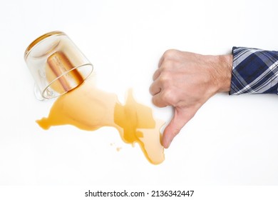 Man In Shirt Showing Dislike. Spilled Coffee Or Tea On The Table Surface. White Background. Top View.