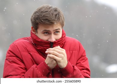 Man Shivering In Cold Winter And Rubbing Hands While Is Snowing