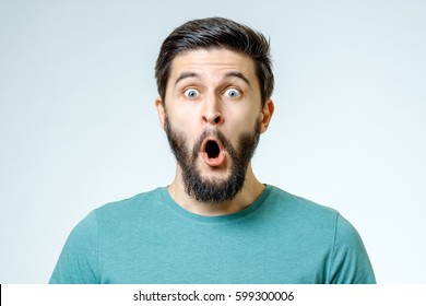 Man with shocked, amazed expression isolated on gray background