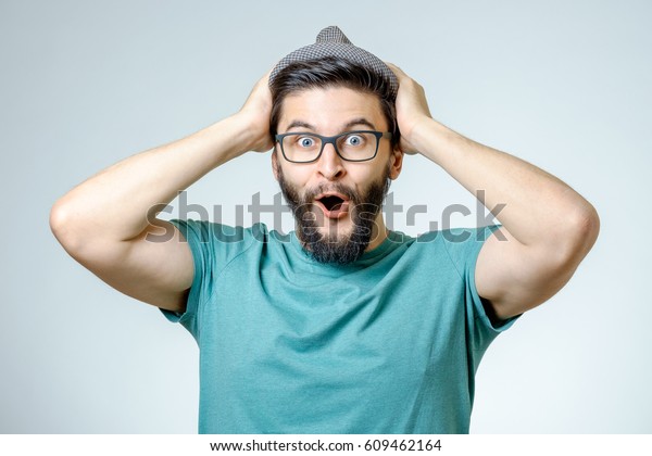 Uomo con scioccato, espressione stupita isolata su sfondo grigio