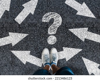 man in shoes standing on asphalt next to multitude of arrows in different directions and question mark, confusion choice chaos concept  - Shutterstock ID 2213486123