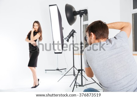 Man shooting female model in studio with softboxes
