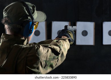 Man Shooting With Gun At A Target In Shooting Range