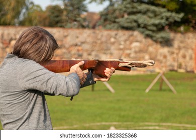 A Man Shoots A Antique Crossbow At A Target