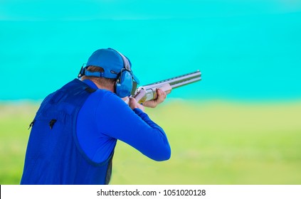 A Man Shoots A Double-barreled Shotgun At A Sports Shooting Range, Shooting At Moving Targets