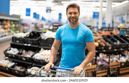 Man with shopping basket full of vegetables and fruits. Middle aged millennial man in a food store. Supermarket shopping and grocery shop concept. Man man 40s with shopping basket. - Powered by Shutterstock