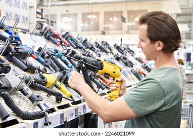 Man shopping drill and perforator in hardware store