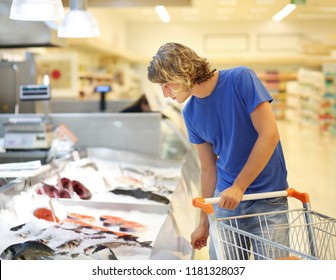 Man shopping for fresh fish seafood in supermarket retail store
