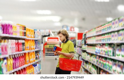 Man Shopping In Supermarket Reading Product Information.(diapers,detergent)