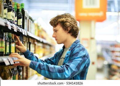  Man shopping in supermarket reading product information.Using smarthone - Powered by Shutterstock