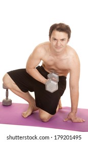 A Man In Shorts Holding A Weight Kneeling Doing A Curl.