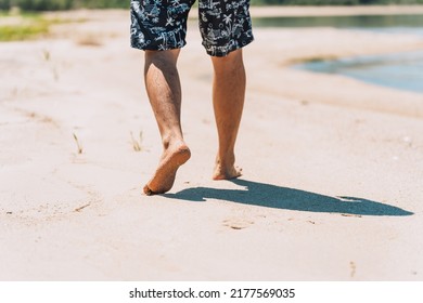 Man In Shorts Walking On The Sandy Beach.