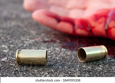 A Man Shot In The Streets With The Bullet Casing Laying Next To A Bloody Hand.