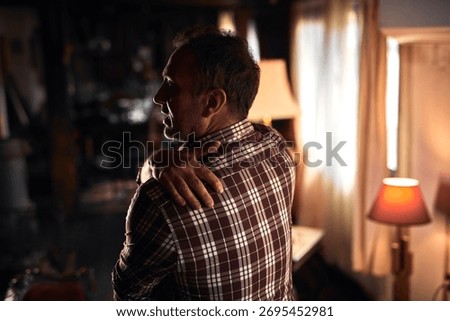 Man with shoulder, muscle, back and sciatica pain at home.