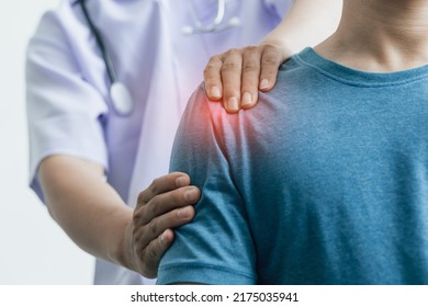 A man with shoulder pain goes to the doctor, The doctor diagnoses the patient's arm pain and shoulder pain. Concept of physical therapy and rehabilitation. - Shutterstock ID 2175035941