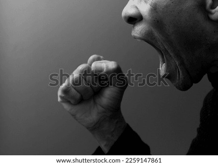 man shouting with anger on grey background with people stock photo	 