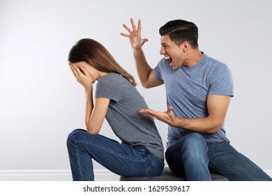 Man shouting at his girlfriend on light background. Relationship problems - Shutterstock ID 1629539617