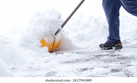 Man shoveling snow off of his driveway after a winter storm in Canada. Man with snow shovel cleans sidewalks in winter. Winter time.