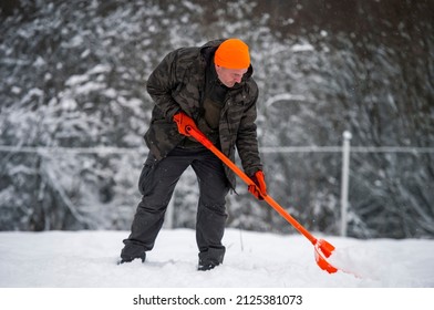 Man Shoveling Snow With Orange Shovel