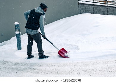 Man Shoveling Snow Outside With A Snow Shovel In Winter