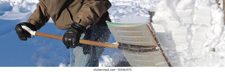 Man Shoveling A Snowy Driveway On A Sunny Day