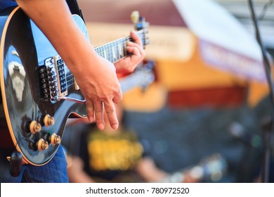 A man show technique of using the electric guitar whammy bar on the concert stage (soft focus)