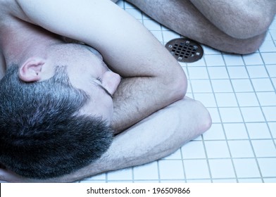 A Man In The Shower Curled Into The Fetal Position.