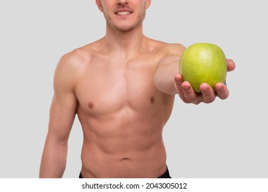 Man Showing Apple Topless. Sportsman with Healthy food in Hands. Muscles, Abs, Biceps, Core. Healthy food, Healthy Eating, Sport, Body, Workout concept