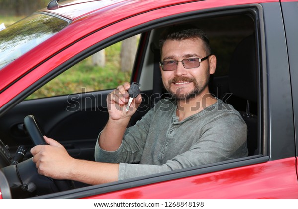 Man showing car key\
from new automobile