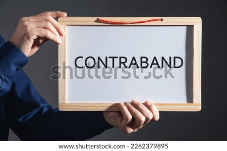 Man showing Contraband word on whiteboard.