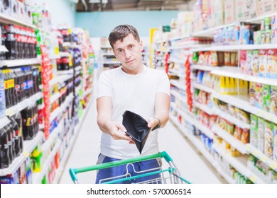 Man Showing Empty Wallet In Supermarket, No Money To Buy, Expensive Food Shopping