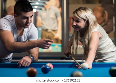 Man Showing His Girlfriend Where To Hit The Ball - Young Caucasian Woman Receiving Advice On Shooting Pool Ball While Playing Billiards