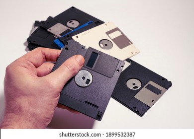 Man Showing Inside Of A Floppy Disk On Scattered Floppy Disks. Old Computer Technology From 1980s And 1990s.