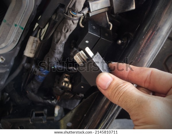 A man\
is showing motorcycle\'s electronic\
component.