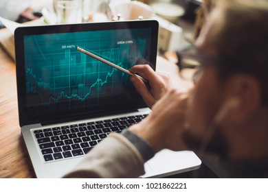 Man showing a peak on the diagram on his laptop.  - Shutterstock ID 1021862221