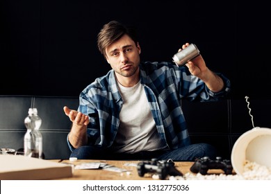 Man Showing Shrug Gesture And Holding Can With Beer After Party