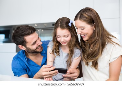 Man Showing Smart Phone To Family At Home