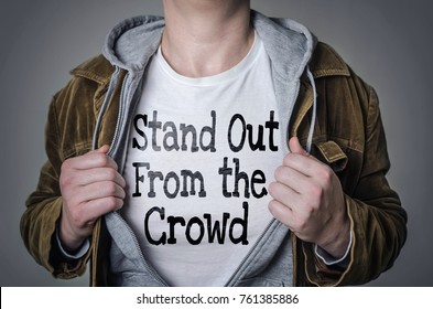 Man showing Stand Out From The Crowd tittle on t-shirt. Talent and uniqueness concept.