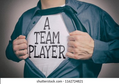 Man Showing A Team Player Tittle On T-shirt. Teamwork, Employees And Business Partners Concept.