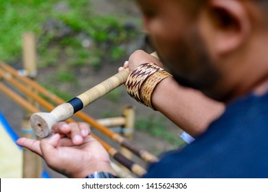 Man showing tourist where to insert poisoned stick into blowpipe