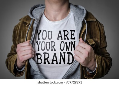 Man showing You Are Your Own Brand tittle on t-shirt. Personal branding concept.