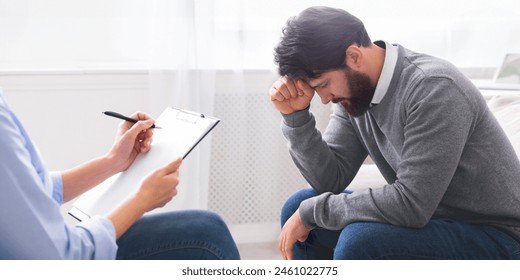 A man is shown seated on a chair, his head cradled in his hands, displaying signs of distress or frustration, deep in thought, experiencing stress or contemplation during session with therapist - Powered by Shutterstock