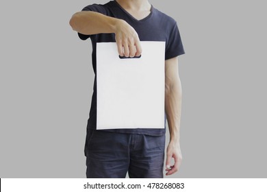 Man shows blank plastic bag mock up isolated. Empty white polyethylene package mockup. Consumer pack ready for logo design or identity presentation. Commercial product food packet handle.