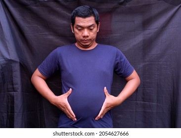 A Man Shows A Distended Stomach.