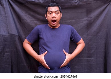 A Man Shows A Distended Stomach.