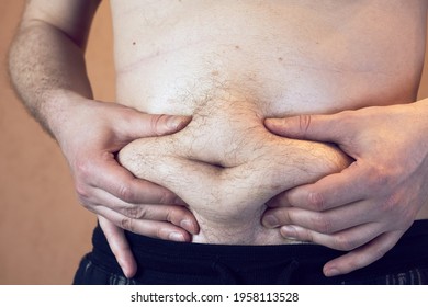 The man shows his hands the fat on his stomach.